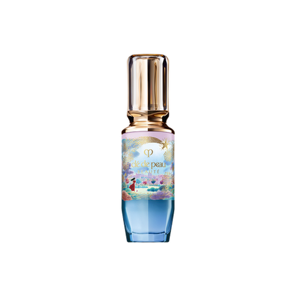 Photo of the 26 AW Holiday Collection limited-edition THE SERUM. The glass bottle features a blue and pink pastel gradient decorated with a gold shooting star and scenery illustration, topped with a clear gold cap.
